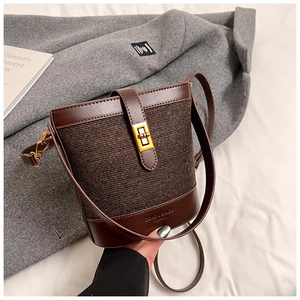 Close-up of brown tweed bucket bag featuring a gold twist-lock and leather trim