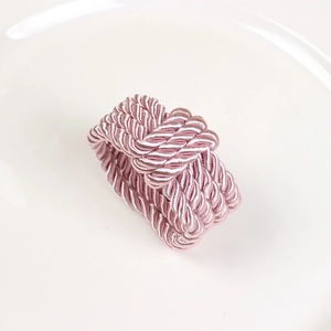 Detailed close-up of pink woven satin napkin ring with silk finish and intricate knot