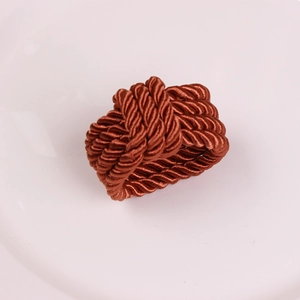 Detailed view of handcrafted dark brown braided rope napkin ring with satin finish