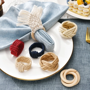 Detail of burgundy woven napkin ring and braided fringe on elegant porcelain dinnerware
