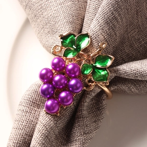 Squisito portatovagliolo con uva di perle viola e foglie di smalto verde su oro