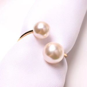 Elegant gold napkin ring featuring twin champagne pearls on a minimalist metal band