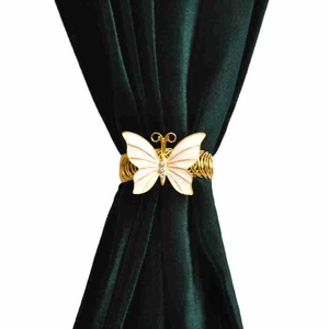 Elegant gold butterfly curtain tieback with white wings and crystals on green velvet