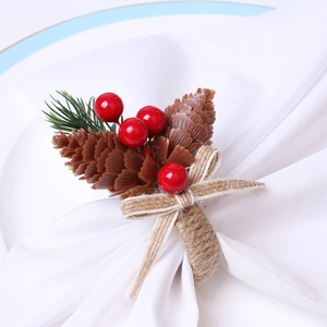 Christmas napkin ring featuring pine cones, red berries, pine needles and a burlap bow