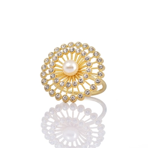 Détail d'un rond de serviette doré avec perle centrale et strass étincelants