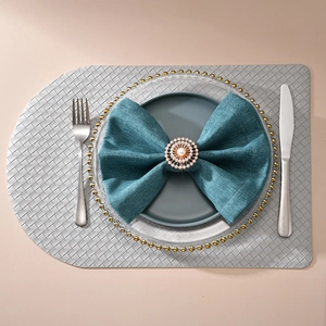 Détail d'un rond de serviette tournesol avec perle et strass sur assiette bleue chic