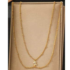 Elegant gold double-layer body chain with delicate beads and a clear round pendant