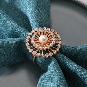 Rond de serviette tournesol or rose avec perle et cristaux sur serviette bleu foncé