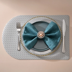 Détail d'un rond de serviette avec perles et strass sur serviette bleue foncée
