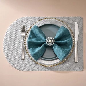 Détail d'un rond de serviette en strass et perle blanche sur une serviette bleu sarcelle