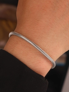 Close-up of a minimalist silver snake bone chain bracelet worn on a woman's wrist
