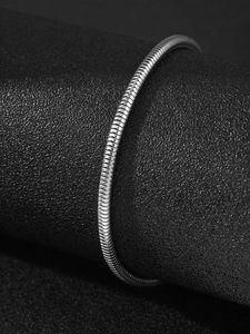 Detailed view of silver snake chain bracelet wrapped on a black leather display stand