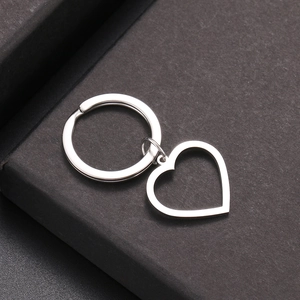 Minimalist stainless steel keychain featuring a hollow heart pendant on a black box surface