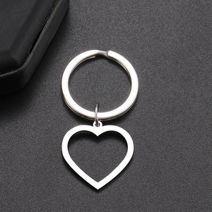 Minimalist stainless steel heart keychain with hollow pendant on matte black surface