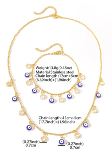 Macro shot of gold Evil Eye necklace and bracelet set in stainless steel with crystal