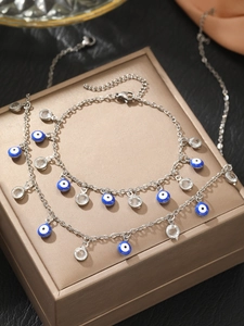 Detail of silver Evil Eye bracelets with enamel charms and crystals on a gift box