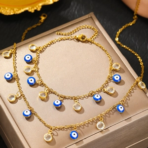 Golden Evil Eye bracelet with blue charms and clear crystals on a metal jewelry box