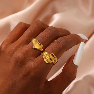 Elegant gold plated heart and ripple rings set worn on fingers with silk background