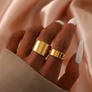 Gold wide band and chain link ring set worn on model with champagne silk background