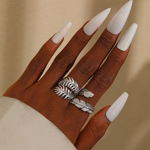 Exaggerated silver leaf titanium steel feather ring on model with white nails
