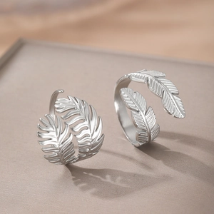 Minimalist silver leaf feather stainless steel open ring with matte finish on grey stand