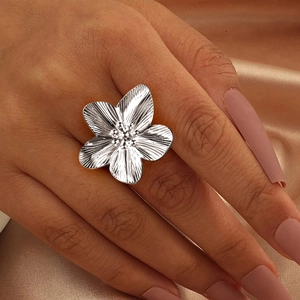 Chic silver stainless steel large flower ring with textured petals on a pink background