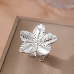 Minimalist silver flower ring with adjustable band and detailed petal texture on display
