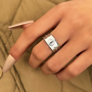 Anello vintage in argento a fascia larga con rilievo a sole indossato da modella