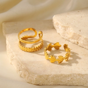 Macro shot of gold leaf texture rings and double layer band on stone tray