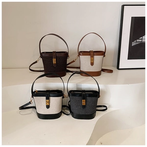 Detailed view of bucket bags in four colors on a white minimalist wave display stand