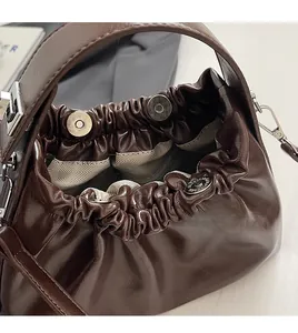 Detail of a dark brown cloud bag showing the silver hardware buckle and magnetic closure