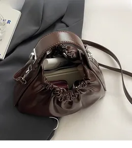Top view of dark brown pleated handbag showing spacious interior and glossy leather texture