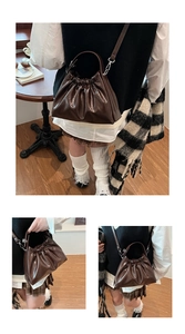 Close-up of pleated dark coffee leather cloud bag with glossy texture and chain strap