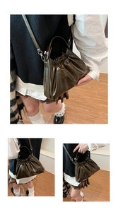 Close-up of olive green wrinkled leather cloud bag with silver chain and handle