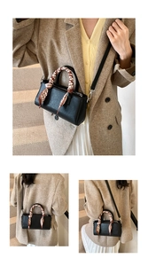 Detailoverzicht van zwarte kunstlederen handtas met decoratieve zijden sjaal en riem