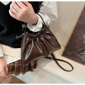 Detail shot of the dark brown ruched leather handbag with a vintage chic chain strap