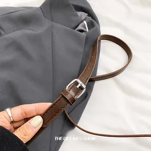 Detail of adjustable brown leather strap with silver metal buckle on autumn handbag