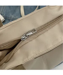 Close-up of durable silver metal zipper and stitching on beige canvas tote bag