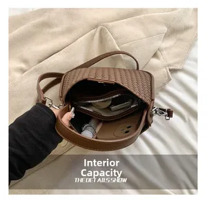 Intérieur spacieux du sac à bandoulière tissé marron avec poche zippée pour essentiels