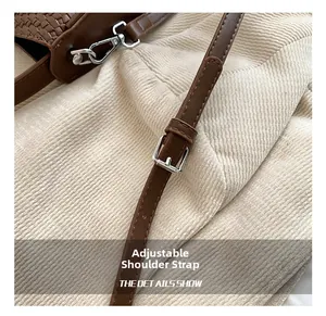 Détail de la bandoulière marron tressée avec boucles en métal argenté brillant