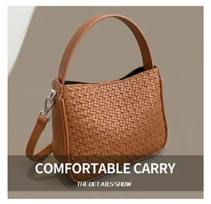 Détail du sac cabas tressé marron montrant la texture, les boucles et la bandoulière