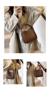 Détail de la texture tissée du sac à main marron foncé avec bandoulière pour femme