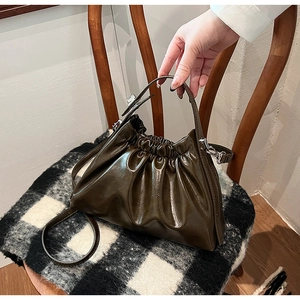Detailed view of dark olive green pleated dumpling bag with soft PU leather texture