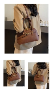 Detail of a brown leather crossbody bag featuring gold hardware and a pebble texture finish
