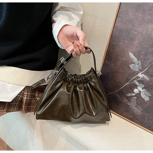 Detail of a dark brown glossy ruched cloud bag with stylish chain strap for women