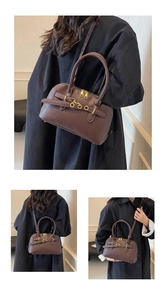 Detail of coffee brown leather handbag showing metal rings and vintage textures