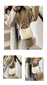 Détail d'un sac à main beige tissé avec finitions en cuir et bandoulière amovible