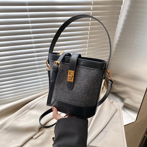 Fashion bucket bag featuring black leather and grey tweed with a golden twist lock