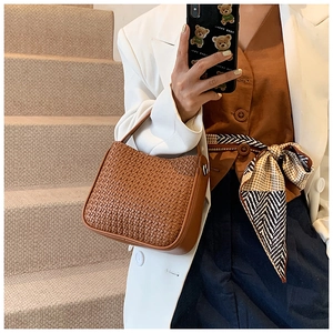 Detail of hand-woven brown leather handbag showing fine texture and artisanal craftsmanship