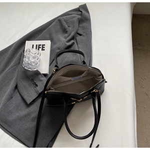 Interior detail of black leather Boston bag with fabric lining and internal pocket slot